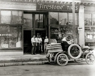 Hommes et camion de réparation de pneus automobiles rassemblés devant la concession de pneus Firestone H. Bender au 4388 Olive Street